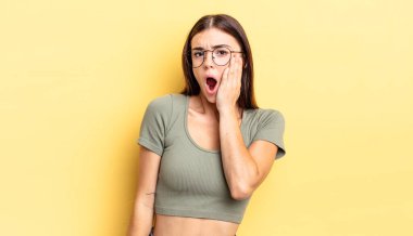 İspanyol güzel kadın şoke olmuş ve ağzı açık bir şekilde yüz yüze inanamamaktan hayrete düşmüş.