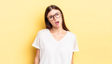 hispanic pretty woman feeling puzzled and confused, with a dumb, stunned expression looking at something unexpected