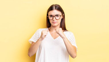 İspanyol güzel kadın kendinden emin, sinirli, güçlü ve agresif görünüyor. Yumrukları boks pozisyonunda dövüşmeye hazır.