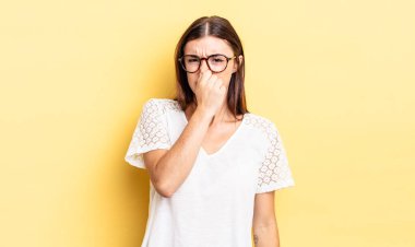 İspanyol güzel kadın iğreniyor, kötü ve nahoş bir koku duymamak için burnunu tutuyor.