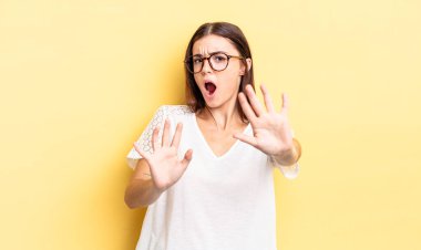 İspanyol güzel kadın korkmuş hissediyor, geri çekiliyor ve korku ve panik içinde bağırıyor, kabusa tepki veriyor.