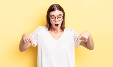 İspanyol güzel kadın şoke olmuş, ağzı açık ve şaşırmış hissediyor, inançsızlık ve şaşkınlık içinde bakıyor ve işaret ediyor.