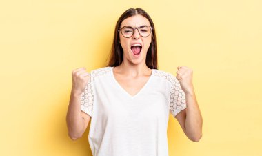 İspanyol asıllı güzel bir kadın öfkeli bir ifadeyle saldırganca bağırıyor ya da yumruklarıyla başarıyı kutluyor.