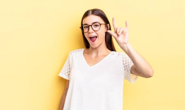 İspanyol güzel kadın kendini mutlu, eğlenceli, kendinden emin, pozitif ve asi hissediyor, elle rock veya heavy metal işareti yapıyor.