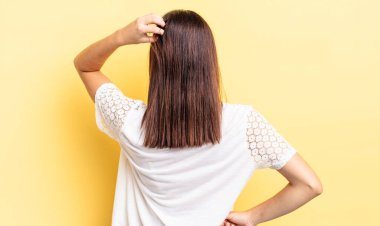 İspanyol güzel bir kadın bilgisiz ve kafası karışık hissediyor, bir çözüm düşünüyor, eli kalçasında, diğeri kafasında, dikiz aynasından.