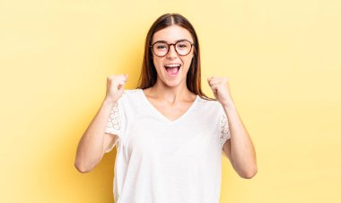 İspanyol güzel kadın mutlu, pozitif ve başarılı hissediyor, zaferi, başarıları veya iyi şansı kutluyor.