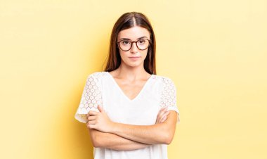 İspanyol güzel bir kadın hayal kırıklığına uğramış, hayal kırıklığına uğramış, ciddi görünüyor, kızgın ve kollarını kavuşturmuş.