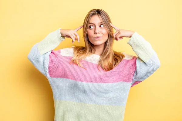 Sarışın, güzel bir kadın. Yoğunlaşmış ve bir fikir üzerinde kafa yoruyor. Bir soruna ya da soruna çözüm bulmayı hayal ediyor.