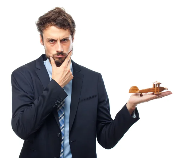 Young crazy businessman with a wooden plane — Stock Photo, Image