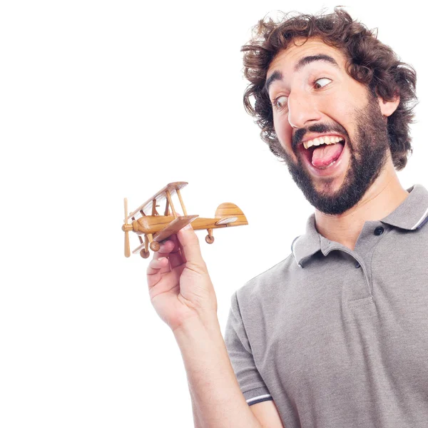 Gek jongeman met een houten vliegtuig — Stockfoto