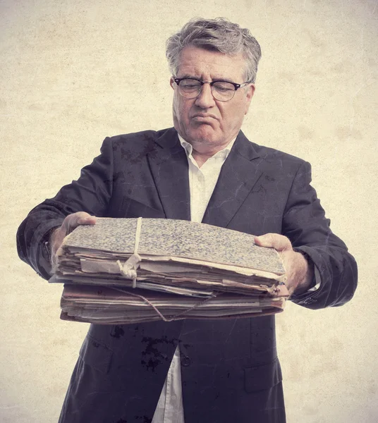 Senior onhartelijk mens met papieren — Stockfoto