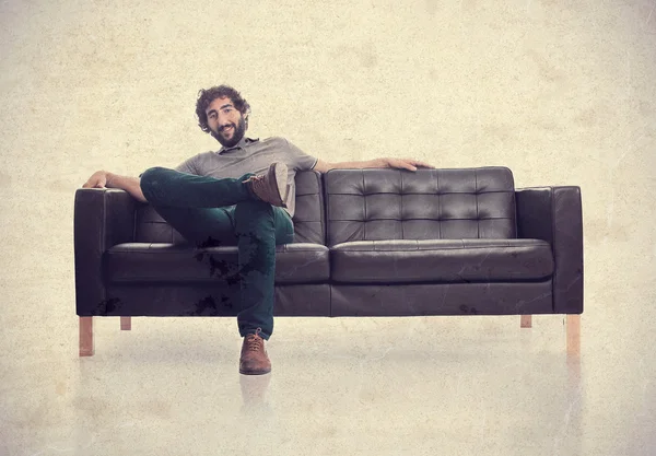Joven hombre satisfecho en un sofá — Foto de Stock