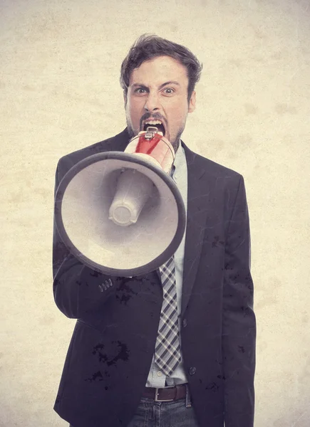 Молодой сумасшедший бизнесмен кричит на мегафон — стоковое фото