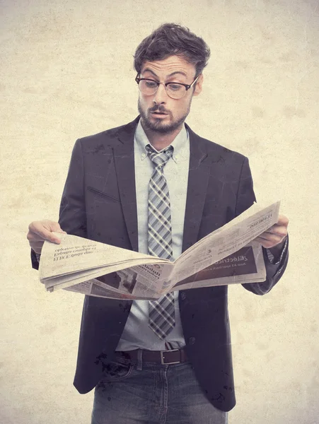 Jonge gek zakenman verrast met een krant — Stockfoto