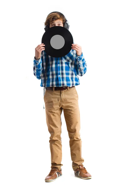 Tonåring med hörlurar håller en vinyl — Stockfoto