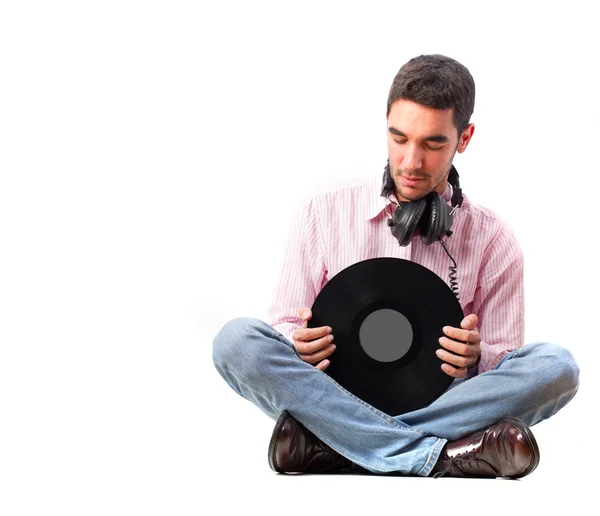 Joven con auriculares sosteniendo un vinilo — Foto de Stock