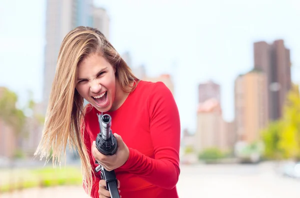 Young cool woman with a gun — Stock Photo, Image
