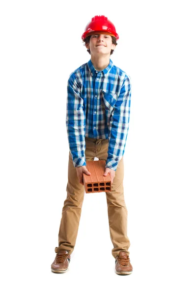 Teenager with work hemlet holding a brick — Stock Photo, Image