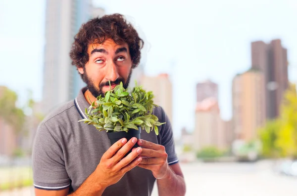 Gek jongeman ruiken een plant — Stockfoto