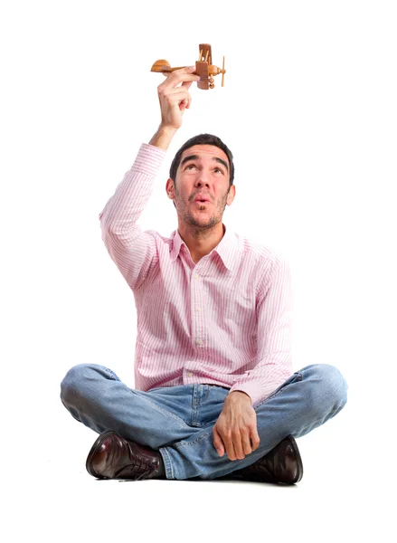 Guy sitting and playing with wood plane — Stock Photo, Image