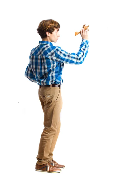 Подросток играет с деревянным самолетом — стоковое фото