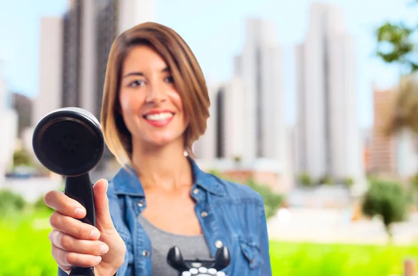 Jovem mulher legal oferecendo um telefone — Fotografia de Stock