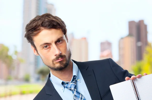 Jeune homme d'affaires fou avec un cahier — Photo