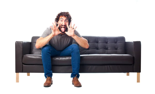 Jonge gek man op een sofa — Stockfoto