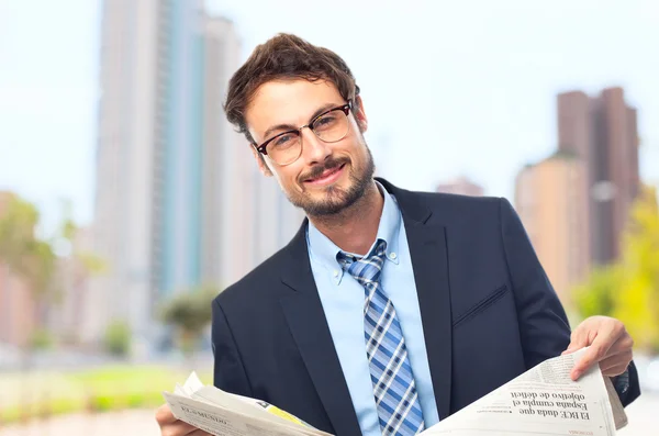 Junge verrückte Geschäftsmann zuversichtlich mit einer Zeitung — Stockfoto