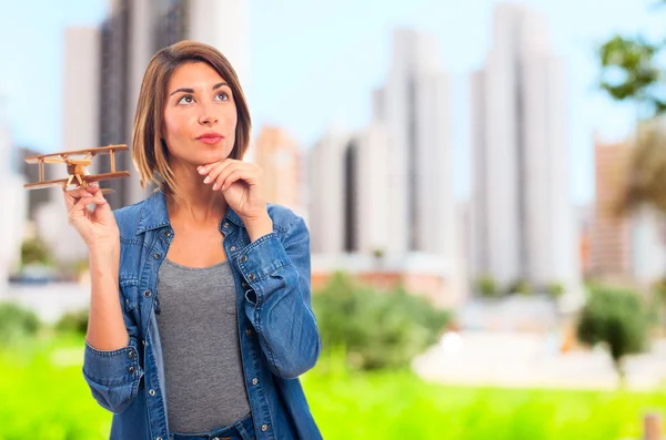 Junge coole Frau mit einem hölzernen Flugzeug — Stockfoto