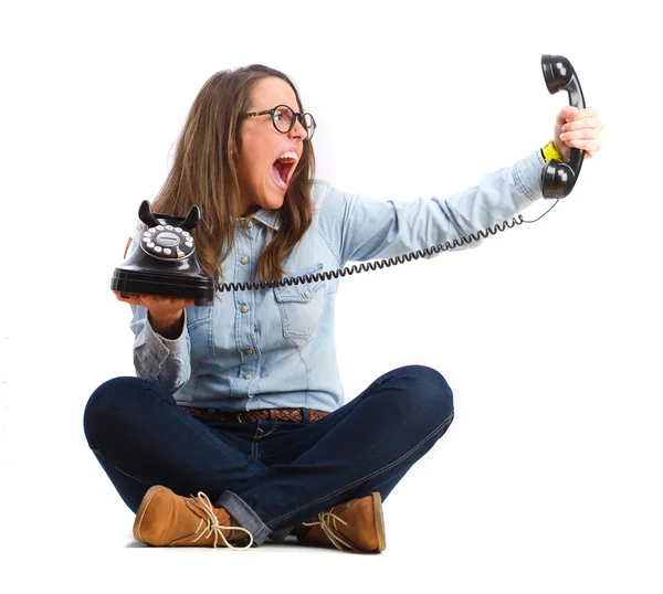 Young woman sitting and shouting with telephone — Stock Photo, Image