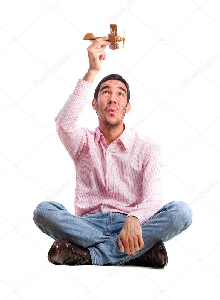 guy sitting and playing with wood plane