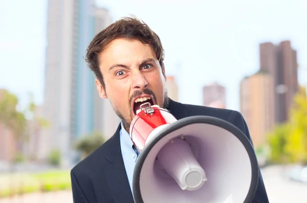 Jonge gek zakenman schreeuwen op megafoon — Stockfoto