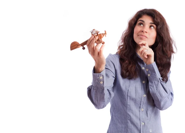 Ragazza pensierosa che tiene un aereo di legno — Foto Stock