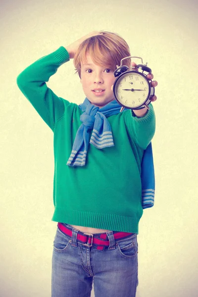 Niño preocupado sosteniendo un despertador — Foto de Stock