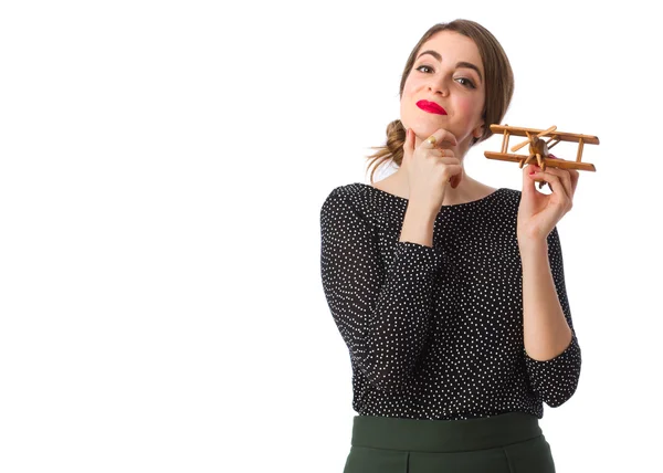 Doordachte meisje met een houten vliegtuig — Stockfoto