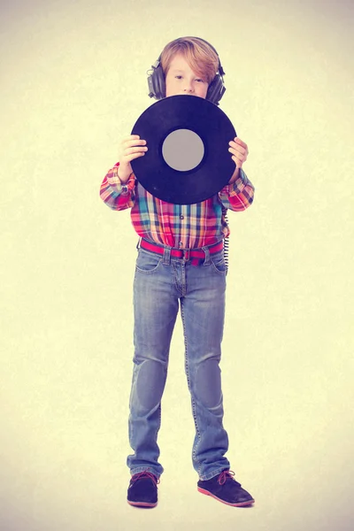 Boy listening music with an headphones and holding a vinyl — Stock Photo, Image
