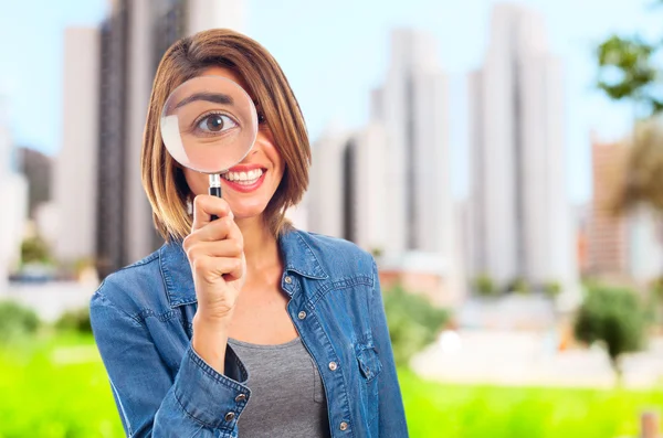 Joven cool mujer con una lupa — Foto de Stock