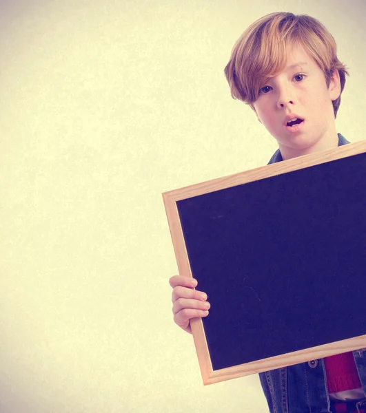 Surprised child holding a blackboard — Stock Photo, Image