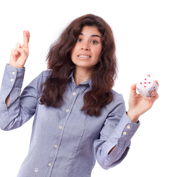 Surprised girl with fingers crossed and holding a die — Stock Photo, Image