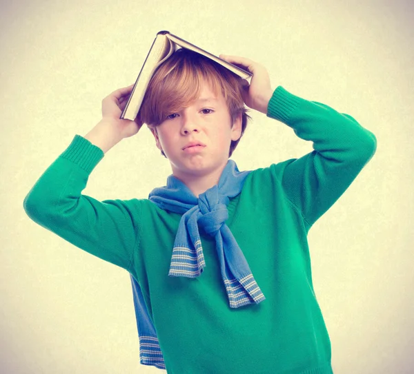 Ragazzo annoiato con un libro in testa — Foto Stock