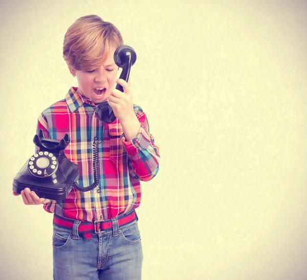 Злой ребенок кричит с телефоном — стоковое фото