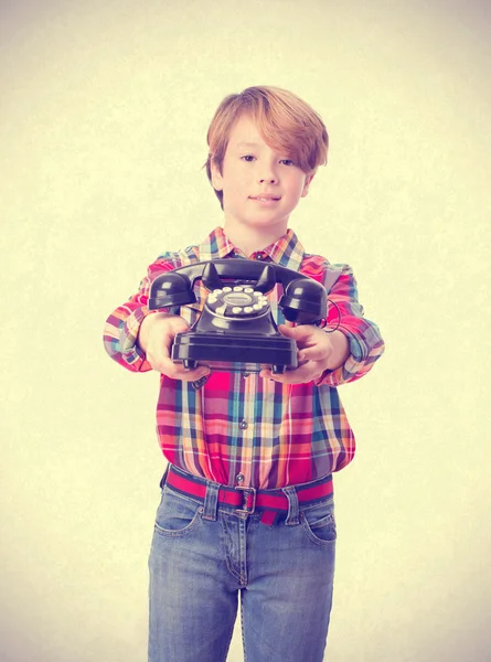 Fiatal fiú gazdaság egy telefon — Stock Fotó