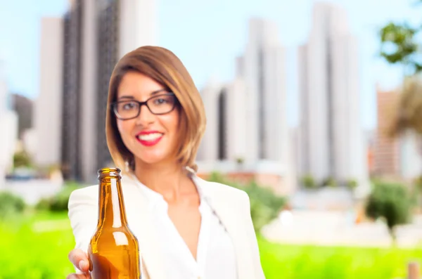 Junge coole Frau bietet ein Bier an — Stockfoto