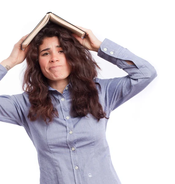 Estudante preocupada com um livro na cabeça — Fotografia de Stock