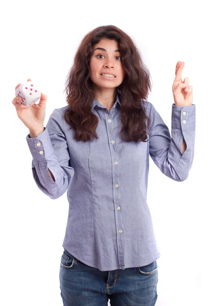 Girl holding a die and fingers crossed gesture — Stock Photo, Image