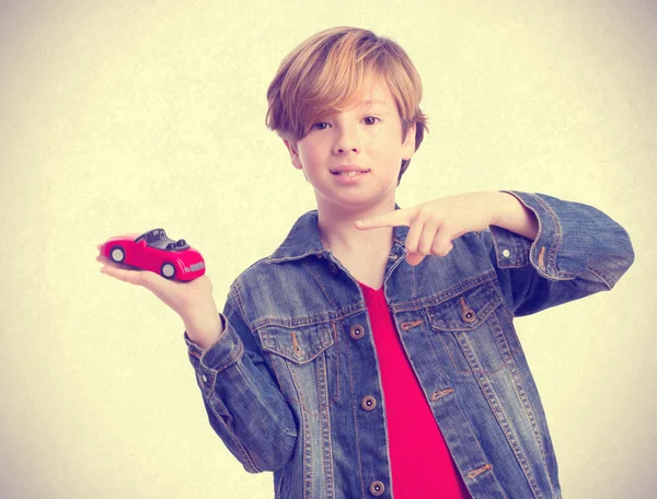 Дитина посміхається і тримає іграшковий автомобіль — стокове фото