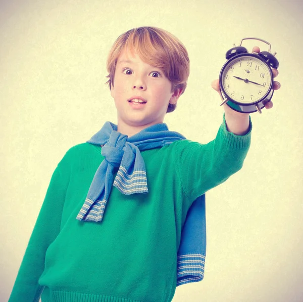 Niño sosteniendo un despertador y preocupado por la hora —  Fotos de Stock