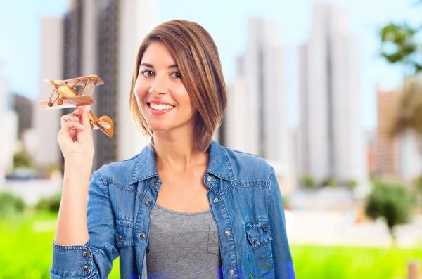 Jovem mulher legal com um avião de madeira — Fotografia de Stock