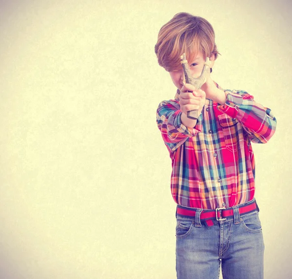 Naughty child pointing with a slingshot — Stock Photo, Image